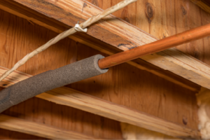 Insulated plumbing pipes under residential home in crawlspace